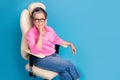 Portrait of clever person with white grey hairdo wear stylish blouse sit on armchair think business isolated on blue