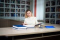 Portrait of clever student with open book reading it in college library. Royalty Free Stock Photo