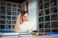 Portrait of clever student with open book reading it in college library. Royalty Free Stock Photo