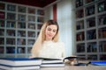 Portrait of clever student with open book reading it in college library. Royalty Free Stock Photo