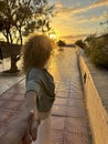 Portrait and close up of adult woman holding hand of boyfriend walking on the street having fun together. Man following girlfriend Royalty Free Stock Photo