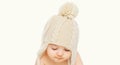 Portrait close up of baby wearing winter knitted hat over a white background Royalty Free Stock Photo