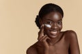 Black girl apply cosmetic cream on face