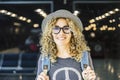 Portrait and close up of beautiful curly and blonde woman looking at the camera smiling - happy people traveling at the airport - Royalty Free Stock Photo