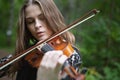 Portrait close up of a beautiful girl violinist who lowered his eyes enthusiastically playing the violin romantic work Royalty Free Stock Photo