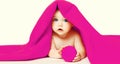 Portrait close up of cute baby lying under pink towel on white background Royalty Free Stock Photo