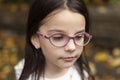 Portrait close up of a cute beautiful little girl in glasses outdoors Royalty Free Stock Photo