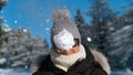 PORTRAIT: Smiling female tourist gets hit in the face by a fluffy snowball.