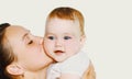 Portrait close up of happy mother kissing her cute baby over white background Royalty Free Stock Photo