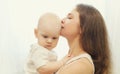 Portrait close up of happy mother kissing her cute baby over white background Royalty Free Stock Photo