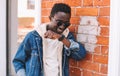 Portrait happy smiling african man with smart watch using voice command recorder or takes calling on a city street Royalty Free Stock Photo
