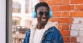 Portrait close up happy smiling african man in wireless headphones listening to music in a city Royalty Free Stock Photo