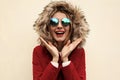 Portrait close up happy smiling surprised young woman wearing red jacket with fur hood