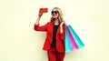 Portrait of happy smiling young woman taking a selfie picture by phone with shopping bags Royalty Free Stock Photo