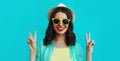 Portrait close up happy smiling young woman wearing a summer straw hat on a blue background Royalty Free Stock Photo