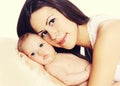 Portrait close up of happy young mother and cute baby lying on the bed at home together Royalty Free Stock Photo