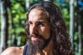 Portrait close up of latino male face. Young handsome man with long hair beard, mustache and trendy hairdo.