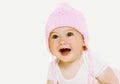 Portrait close up of laughing baby wearing knitted pink hat over a white background Royalty Free Stock Photo