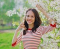 Portrait of lovely young woman in a spring blooming garden on a white flowers background Royalty Free Stock Photo