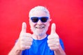 Portrait and close up of mature and old man wearing blue sun glasses and smiling looking at the camera - cheerful and happy senior Royalty Free Stock Photo