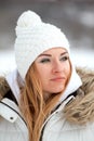 Portrait close up of red-haired beautiful young woman in white knitted hat outdoors. Vertical frame Royalty Free Stock Photo