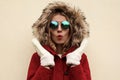 Portrait close up shocked young woman wearing white mittens, red jacket with fur hood