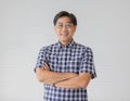 Portrait close up shot of middle aged asian male model with short black hair wearing blue plaid shirt with stand smiling fold his Royalty Free Stock Photo