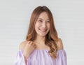 Portrait close up shot of young pretty asian female with long brown hair wearing light purple long sleeve shirt stand smiling to Royalty Free Stock Photo