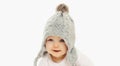 Portrait close up of smiling baby wearing winter knitted gray hat over a white background Royalty Free Stock Photo