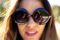 Portrait close up of smiling fit caucasian woman wearing sunglasses in sunny garden Royalty Free Stock Photo