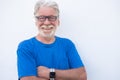Portrait close-up of a smiling senior man with white beard on white background wearing eyeglasses and tshirt in blue color. Royalty Free Stock Photo