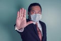 Portrait close up at to hand businessman showing the stop sign. Asian businessman portrait wears a black suit wearing medical