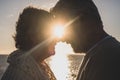 Portrait and close up of two happy in love seniors looking to each other smiling with the sun of the sunset between their heads Royalty Free Stock Photo
