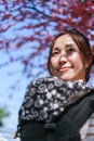 Portrait of close up woman standing looking and smiling happy carrying bag black white cherry blossom background Royalty Free Stock Photo