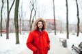 Portrait, close-up of a young stylishly dressed man smiling with a beard dressed in a red winter jacket with a hood and fur on his Royalty Free Stock Photo