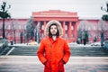 Portrait, close-up of a young stylishly dressed man smiling with a beard dressed in a red winter jacket with a hood and fur on his Royalty Free Stock Photo