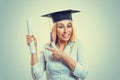 Happy graduate pointing showing diploma scroll