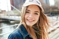 Portrait closeup beautiful young girl in city. Smiling girl in hat Royalty Free Stock Photo