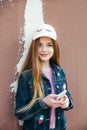 Portrait closeup beautiful young girl in city. Smiling girl in hat with smartphone Royalty Free Stock Photo