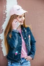 Portrait closeup beautiful young girl in city. Smiling girl in hat with smartphone Royalty Free Stock Photo