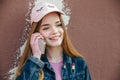 Portrait closeup beautiful young girl in city. Smiling girl in hat with smartphone Royalty Free Stock Photo