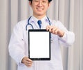 Doctor in uniform and stethoscope neck strap showing front blank screen smart digital tablet on hand