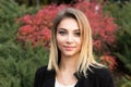 Portrait of nice young woman against background of summer green park red green leaves beautiful woman Royalty Free Stock Photo