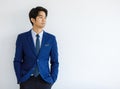 Portrait closeup shot of Asian young handsome happy intelligence college teen student wears blue formal suit and necktie standing Royalty Free Stock Photo