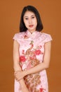 Portrait closeup studio shot millennial Asian female model in pink Chinese cheongsam qipao traditional peacock & flowers pattern Royalty Free Stock Photo