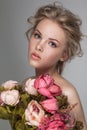 Portrait closeup of a young beautiful blonde woman with fresh flowers.