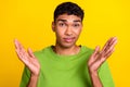 Portrait of clueless indifferent young man raise arms palms not know isolated on yellow color background