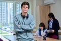 Portrait of college student guy looking at camera inside classroom