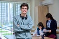 Portrait of college student guy looking at camera inside classroom