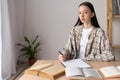 Portrait of a college student sitting at a table with textbooks, female student doing homework in the classroom, home Royalty Free Stock Photo